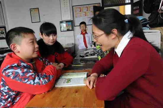 昨天，永川永红小学教室，老师给夏世钢补课，陈世连(中)在一旁听着，回家后可以提醒儿子。 上游新闻记者 李斌 摄
