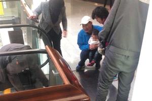 女童手指被夹断后,蹲在地上的爷爷把她抱在怀里。目击者供图