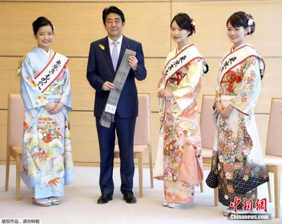 当地时间2015年12月8日,日本东京,首相安倍晋三在官邸接见“和服女王”,并获赠传统和服腰带。