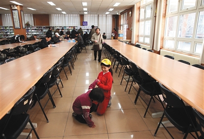北京八中,一9岁女孩报名少儿班,她的妈妈在咨询报名,她和弟弟在玩耍。