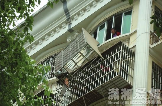 4月15日,长沙中南汽车世界G6栋,脱离 墙体的护窗摇摇欲坠。图/潇湘晨报记者陈斌