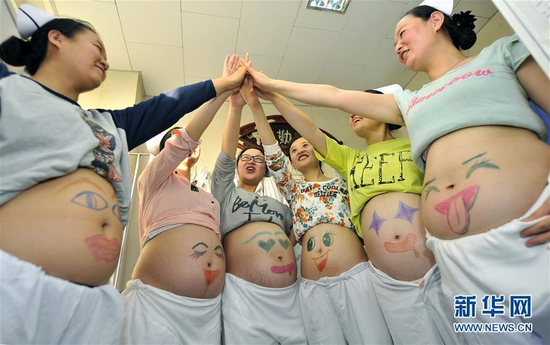 5月11日，在山西省人民医院，神经外科的“准妈妈”护士们展示画上笑脸的肚子。当日，山西省人民医院神经外科几名怀孕的护士下班之后在自己的大肚子上画上笑脸，用特别的方式庆祝即将到来的“5·12”国际护士节。