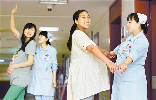 张童欣（左二）和郭琴（左四）正在“孕妇学校”指导准妈妈做运动。 记者 张锦辉 摄影报道