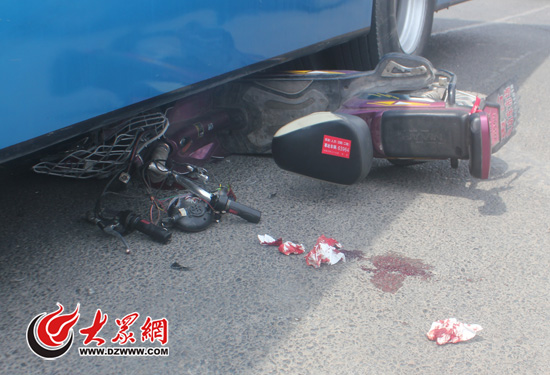 电动车前半部分和男童一起被卷入公交车车底。