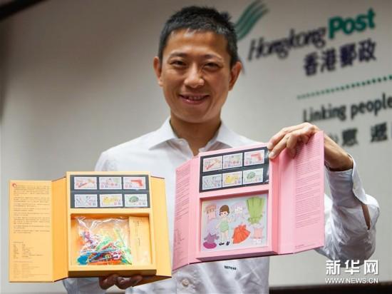 工作人员向记者展示“香港玩具——1940至1960年代”两套纪念套摺。