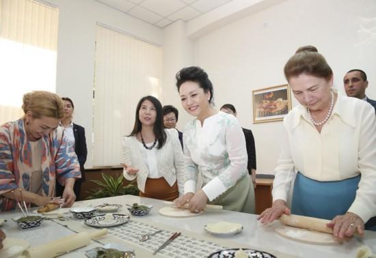 在厨艺课堂,彭丽媛为学生讲解示范包饺子。新华社记者丁林摄