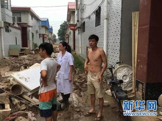 周群妻子(中)在灾区消毒 (图片来源:邢台公安微信公众号)