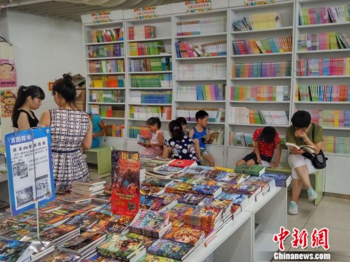 图为暑期家长带着孩子来书店看书。吕春荣 摄