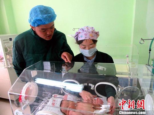当晚,民警将婴儿抱进医院。 胡静 摄