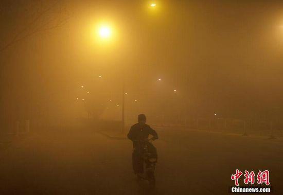 12月18日，北京市民在雾霾中出行，能见度极低。中新社记者 刘关关 摄