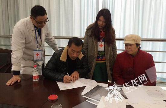 小月父亲邓师傅在登记表上签字。 市红十字会供图 华龙网发