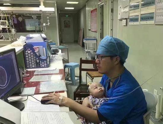 医生边打点滴边哄患儿。
