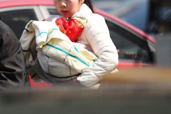 ▲2月15日,长沙今日最高温度达20℃。在湖南省儿童医院,即使天气很热,小孩仍被包裹得严严实实。图|记者金林