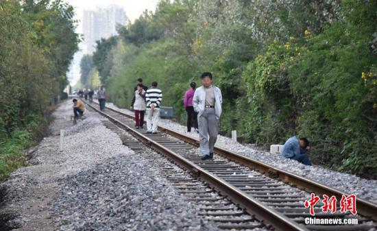 资料图片，市民在铁路上散步。图片来源：CFP视觉中国