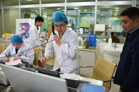 安徽医科大学第一附属医院产科的张晓慧医生(前中)为一位急需入院的产妇联系加床(2016年3月15日摄)。新华社记者 郭晨 摄
