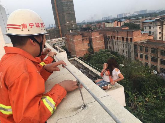 消防官兵正在设法救下母子俩。