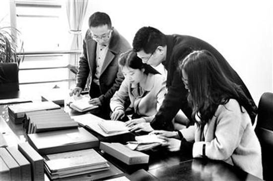 执纪审查人员在查看陡沟中学助学金发放账目。中国纪检监察报 图