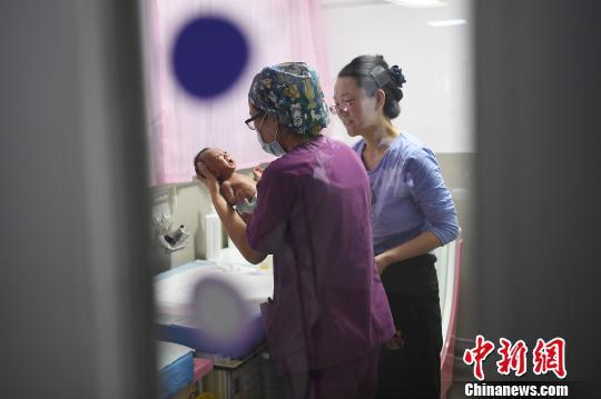 母亲正在与护士一路护理孩子。 武俊杰 摄