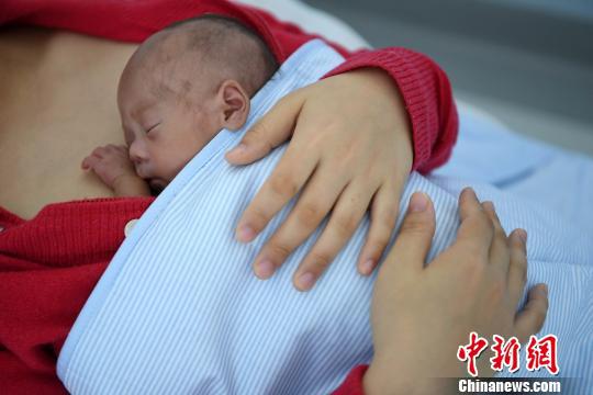 婴儿紧贴在妈妈胸口,聆听着心跳及呼吸。 武俊杰 摄