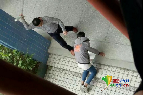 张姓先外行拿带插线板的电线殴打跪在地上的学生。