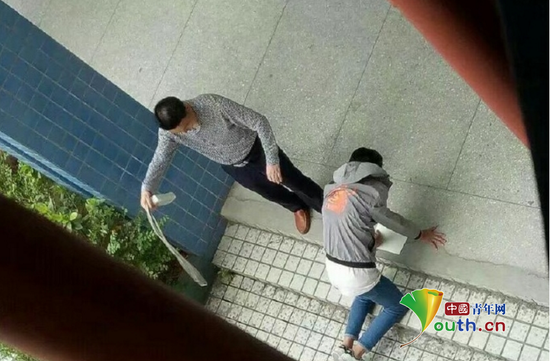 张姓先外行拿带插线板的电线殴打跪在地上的学生。