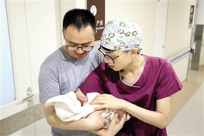 李茂(右)给新生儿家属讲解日常护理知识。记者 平索茜 摄