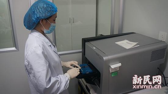 图说：遗传室工作人员正在操作芯片。医院供图