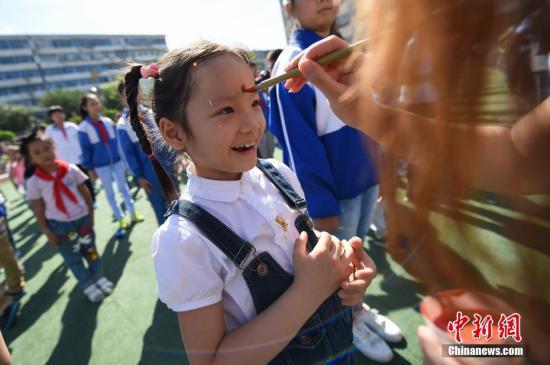 资料图：老师们为新入学的小学生们点朱砂，行“开笔礼”。武俊杰 摄