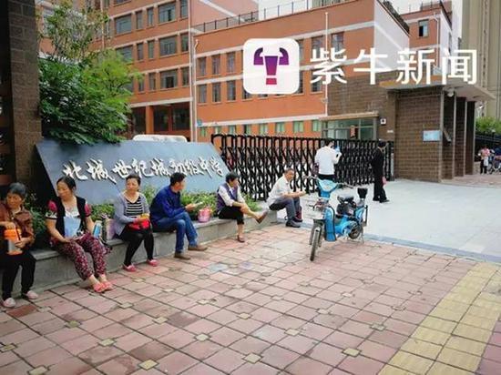 家长在黉舍门口等孩子下学。
