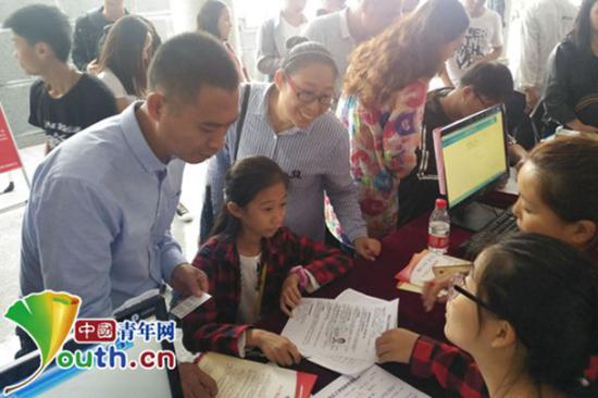 张易文在父母的陪护下解决入学手续。