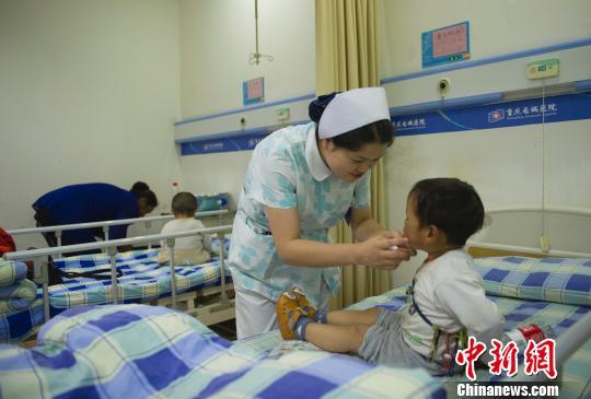 图为前来治疗的患儿接收检查。 重庆平易近政局供图 摄