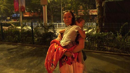 8月12日凌晨4点多，李少云抱着已经睡着的依依回家。  澎湃新闻记者 朱莹 图