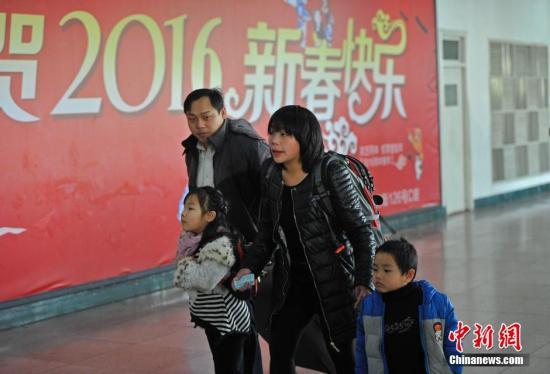 2月3日,山西太原火车站,一对夫妻领着他们的两个孩子匆忙赶车。中新社记者 韦亮 摄