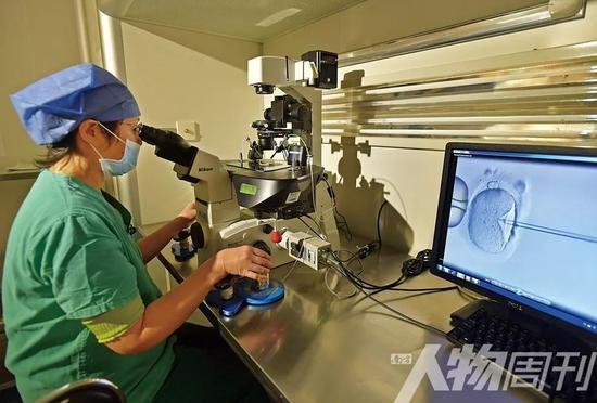 武汉协和医院生殖医学中心胚胎移植实验室，医生正将精子注入卵子。由于生二胎者增多，做试管婴儿的妇女平均年龄已增长了两岁