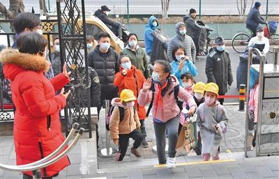 2月27日，东城区回民小学，校长老师在校门口迎接学生返校。学生提交寒假作业并领取新书，为3月1日开学做准备。　　新京报记者 李木易 摄