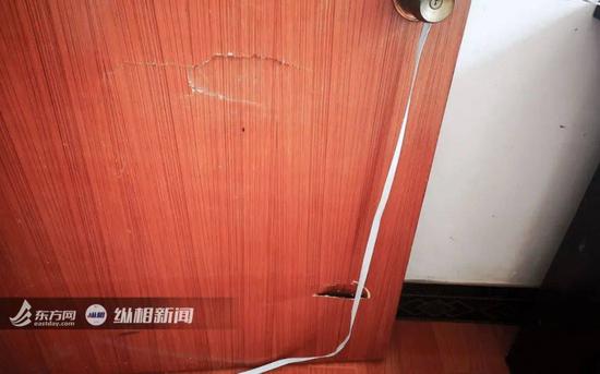 在康康父母家，房间门上留有被踹裂的痕迹。