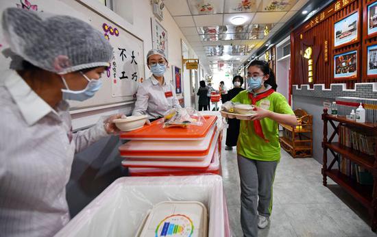 午餐时间，“学生”保持安全距离领取午餐。