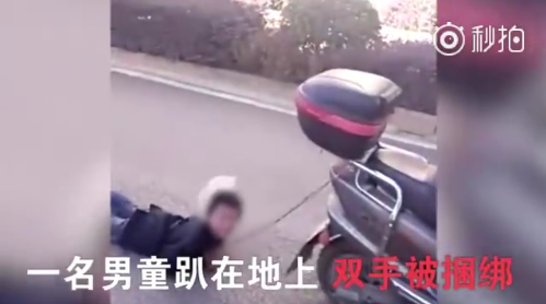 男童趴在地上 双手被绑缚