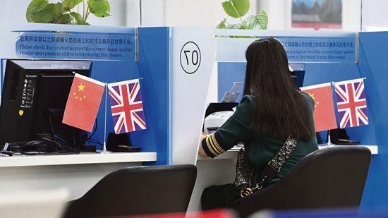 图为7月3日，市民在位于北京的英国签证申请中心办理签证相关手续。（图片来源：中新社）