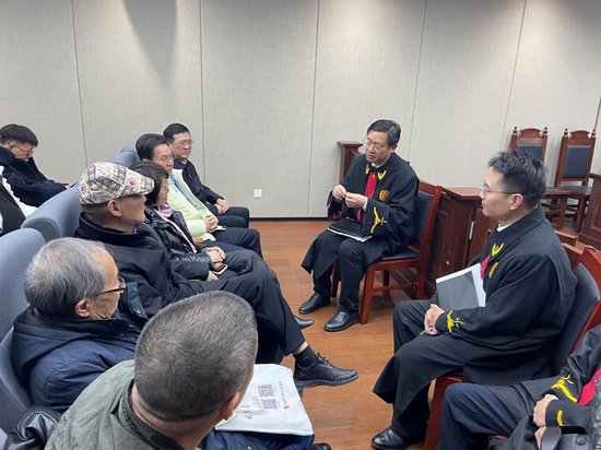  作家们在合肥法务区旁听庭审后，与主审法官交流。