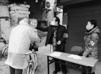武汉出版集团职工（右一、右二）在武汉市江汉区常青街道冠生园宿舍院出入口执勤，参与社区疫情防控。
