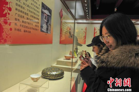 观众在现场观看带有吉语纹饰的清宫文物。 于海洋 摄