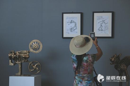 市民用手机记录下雕塑作品的创作图稿。