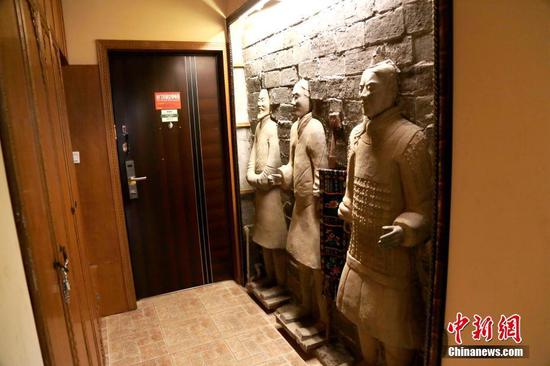 11月27日,民宿进门处的三尊“兵马俑”装饰如同门神。 中新社记者 张远 摄