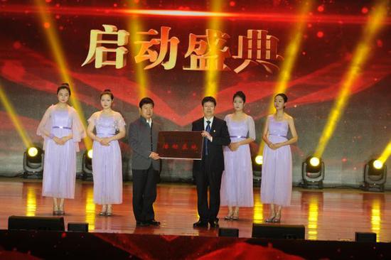 (中国教育电视台党委书记、副台长柯春晖代表中国教育电视台授予怀仁市一中“诗意中国进校园活动基地”,怀仁一中校长仝贵军接赠。)
