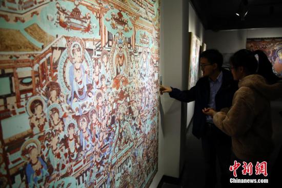 资料图:精美的敦煌壁画吸引参观者。 汤彦俊 摄