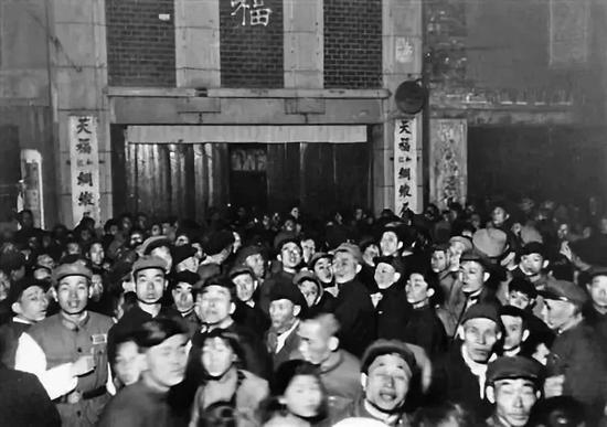 梅兰芳演出时,买不到或买不起票的市民在天福门口听演出广播