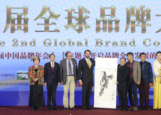 图  第二届全球品牌大会活动赠礼现场  左二为中国国际文化传播中心执行主席龙宇翔、左三为英国易男爵、左四为德国乔治康斯坦丁王子、右四为作品作者黄俊杰先生