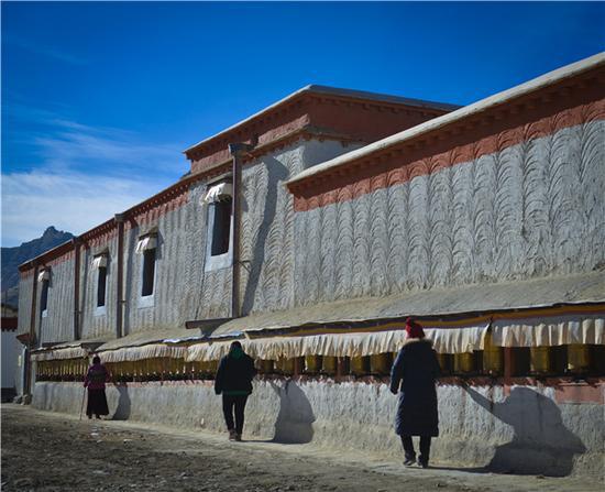 在托林寺转经筒前转经的藏民