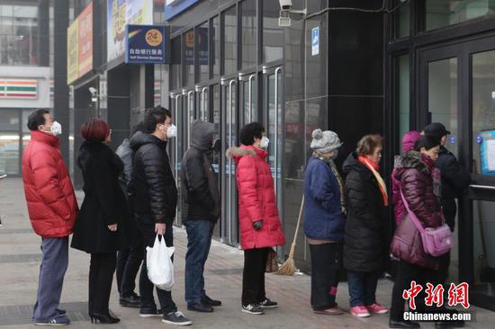 北京市民排队兑换鸡年贺岁纪念币。 中新社记者 李慧思 摄